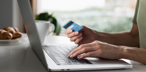 Woman using laptop computer with credit card making online payment. Business, online shopping, e-commerce, internet banking, spending money, working from home concept