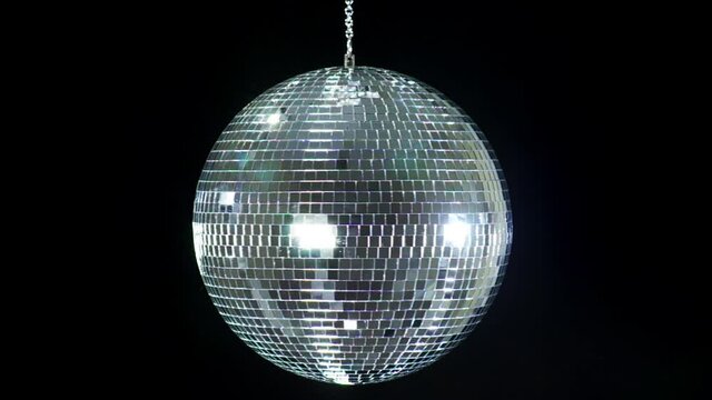 Mirror ball reflects white light. Disco ball with reflected moving rays.
