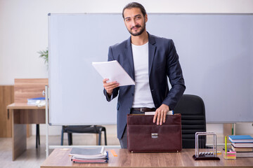 Young male teacher physicist in the classroom