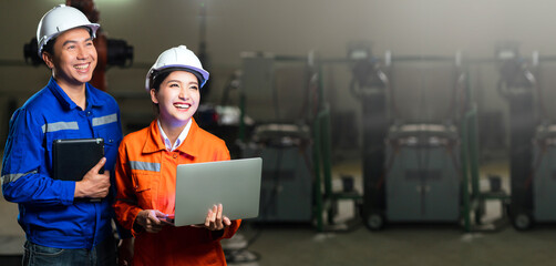 portrait of asian emgineer male female technician in safty uniform standing and turn around to look...