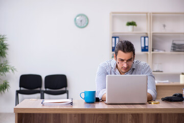 Young male bookkeeper working in the office