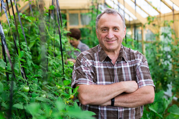 Portrait of elderly man posing in the greenhouse