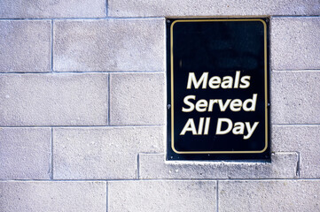 Fototapeta premium Meals served all day sign on wall of restaurant