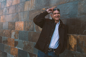 adult man in jeans and jacket on the wall