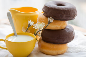 delicious sugary chocolate donuts with cup of milk