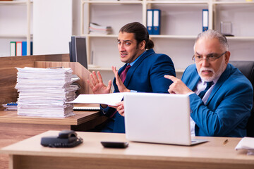 Old male boss and his young male assistant in bullying concept