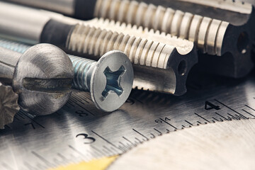 set of different nuts, bolts, screws, washers and drill bits,thread tap and mill cutters on steel plate background. Locksmithing deal.