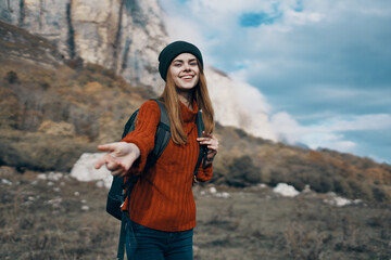 woman in sweater stretches out her hand to the camera outdoors in autumn travel tourism model