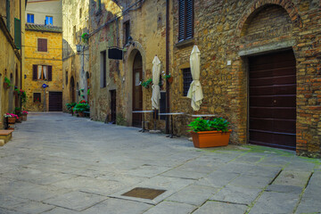 Idyllic street with flowers and flowerpots in Tuscany, Pienza, Italy