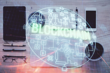 Double exposure of blockchain theme hologram over table with phone. Top view. Crypto technology concept.