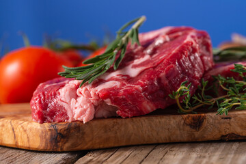 Raw beef steak close-up, with rosemary on a background with vegetables. Meat Recipes, Recipe Book, Selling Meat in Market or Store on Banner