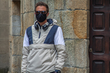 Fototapeta na wymiar man through the monumental streets with medical mask and headphones in the new normal