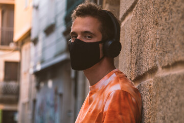 man through the monumental streets with medical mask and headphones in the new normal
