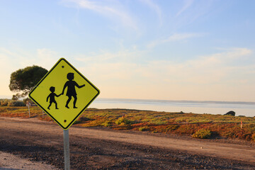 mother and child pedestrian crossing sign at the beach