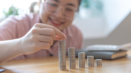 Woman's hands put the coins arranged in steps, Managing your finances or saving money for future use, Saving for investment, Saving money for business growth or long-term profitability.