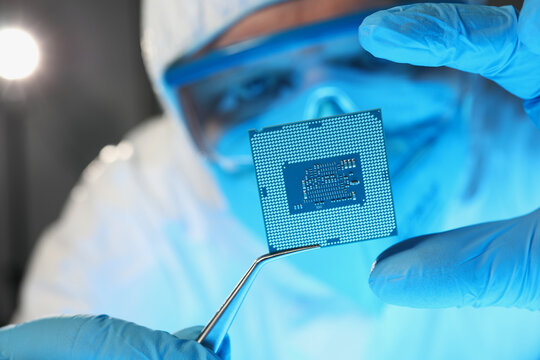 Scientist developer in protective suit holds microcircuit