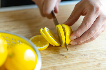 Woman cutting lemons in kitchen.

