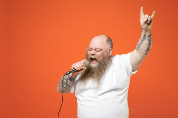 Fat pudge obese overweight tattooed blue-eyed bearded big belly man in white t-shirt sing song in...