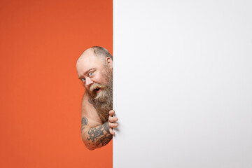 Fat fun happy pudge overweight tattooed bearded man 30s with naked torso hold big white empty blank...