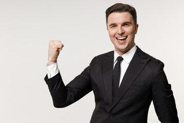 Young happy fun successful employee business corporate lawyer man in classic formal black grey suit shirt tie work in office do winner gesture clench fist isolated on white background studio portrait.