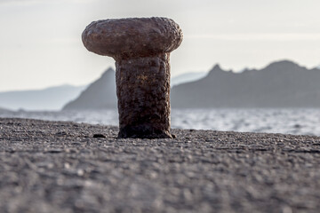 Profile of a rusted bollard left alone in the Aegean coast of Turkey, Turgutreis with Greek islands...