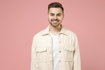 Young smiling happy positive cheerful fun trendy fashionable caucasian man 20s in jacket white t-shirt looking camera isolated on pastel pink color background studio portrait People lifestyle concept