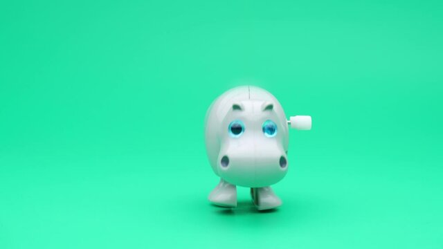 Clockwork hippopotamus runs on a freen background. 