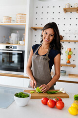 Beautiful young woman cooking in the kitchen. Healthy, organic, food concept