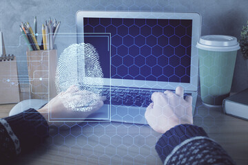 Double exposure of woman hands typing on computer and fingerprint drawing. Security concept.