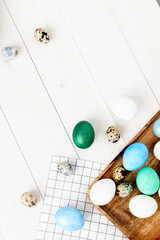 multicolored easter eggs on chalkboard on wooden background top view