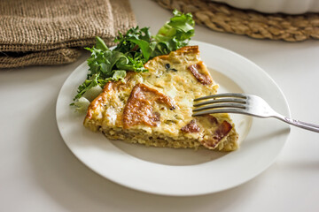 Slice of French onion pie on a white plate with a fork