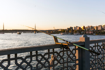 Fototapeta na wymiar Still life image of a fishing rod attached to the deck of the Galata Bridge at the Golden Horn, Istanbul, by someone at late afternoon.