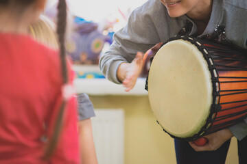 The girl plays the Djembe drum for children