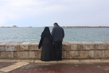Friendly Arab family admire the view of the Mediterranean Sea on the waterfront in Alexandria,...