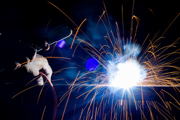 Iron welding close-up, sparks do not wear gloves. Welding sparks and fumes It can be dangerous to...