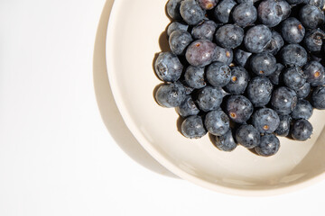Fresh Blueberries in a bowl on white background.Juicy wild forest berries, bilberries.Healthy eating or nutrition.