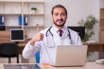 Young male doctor sitting in the office