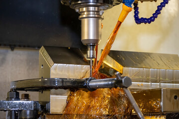 The CNC milling machine cutting the  mold parts with oil coolant method. The mold and die...
