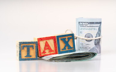 Tax wooden cube and banknotes with tax concept.
