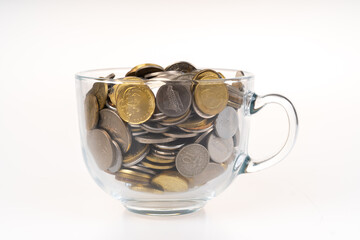 Coins in transparent cup glass.