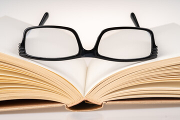 Book and black spectacle with close up view.