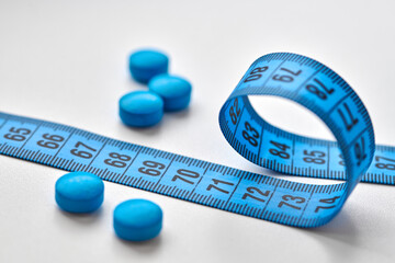 Pills, drugs and measuring tape isolated on white background