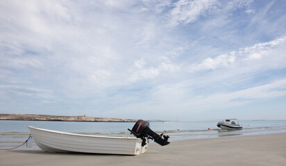 Langebaan Lagoon, South Africa. A Beautiful tourist destination with rocky coastline and boats with wispy cloud blue sky.