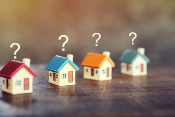 looking for new home, buy or rent real estate concept with miniature house model with question mark