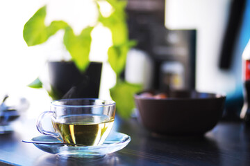 Hot steaming green tea in a cup on a rustic background