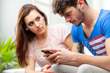 Serious young man reading a message or watching media on his mob