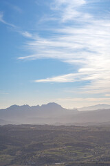 Obraz premium Mountain between villages on a clear day with few clouds, the sea in the background. In Alicante, Spain.