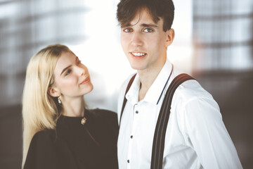 Young couple of businessman and woman are standing in a modern office. Portrait of successful business people