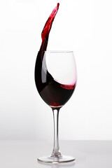 Rotwein im Glas mit spritzer aus dem Weinglas und platz für text