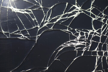 Crack on the glass. Broken screen. Broken phone. Cracked glass background. White cracks in the glass.